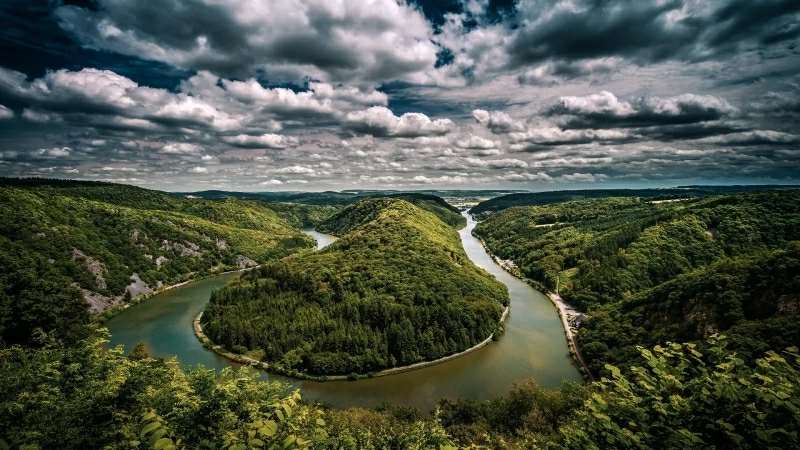 Aerial View Of River Between Green Trees Covered Forest Under Cloudy Sky HD Nature Wallpaper