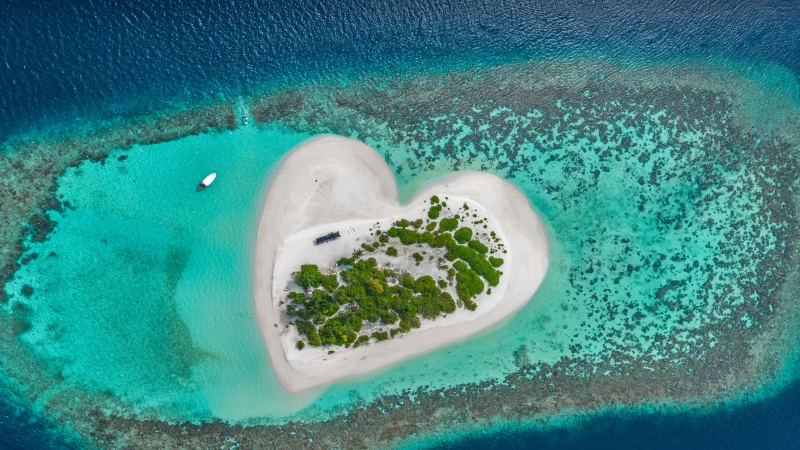 Heart-shaped island with sandy beach, offshore coral reef, Indian Ocean, Maldives