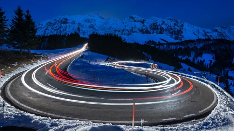 Photography Of Curved Lighting Road Surrounded Snow Covered Mountains 4K 5K HD Wallpaper