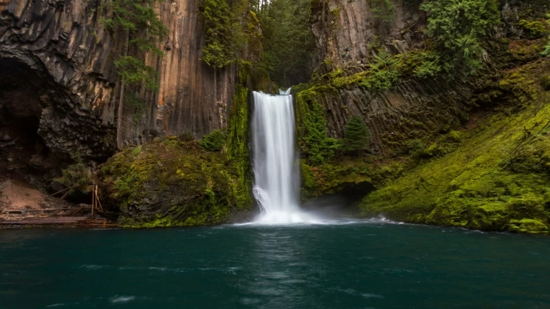 Black Brown And Green Covered Rocks Between Waterfall During Daytime 4K HD Nature Wallpaper