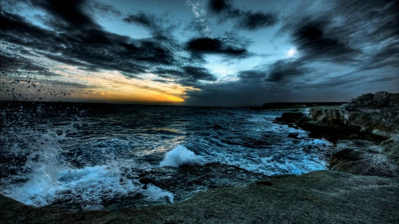 Dark Clouds Under Rough Sea With Brown Rocks During Sunset Time 4K 5K HD Nature Wallpaper