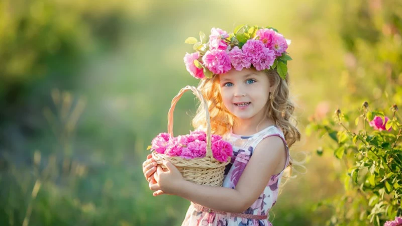 Blue Eyes Cute Little Girl Is Wearing Flowers Printed Dress Having Flower Basket In Hand Standing In Blur Green Background HD Cute Wallpaper